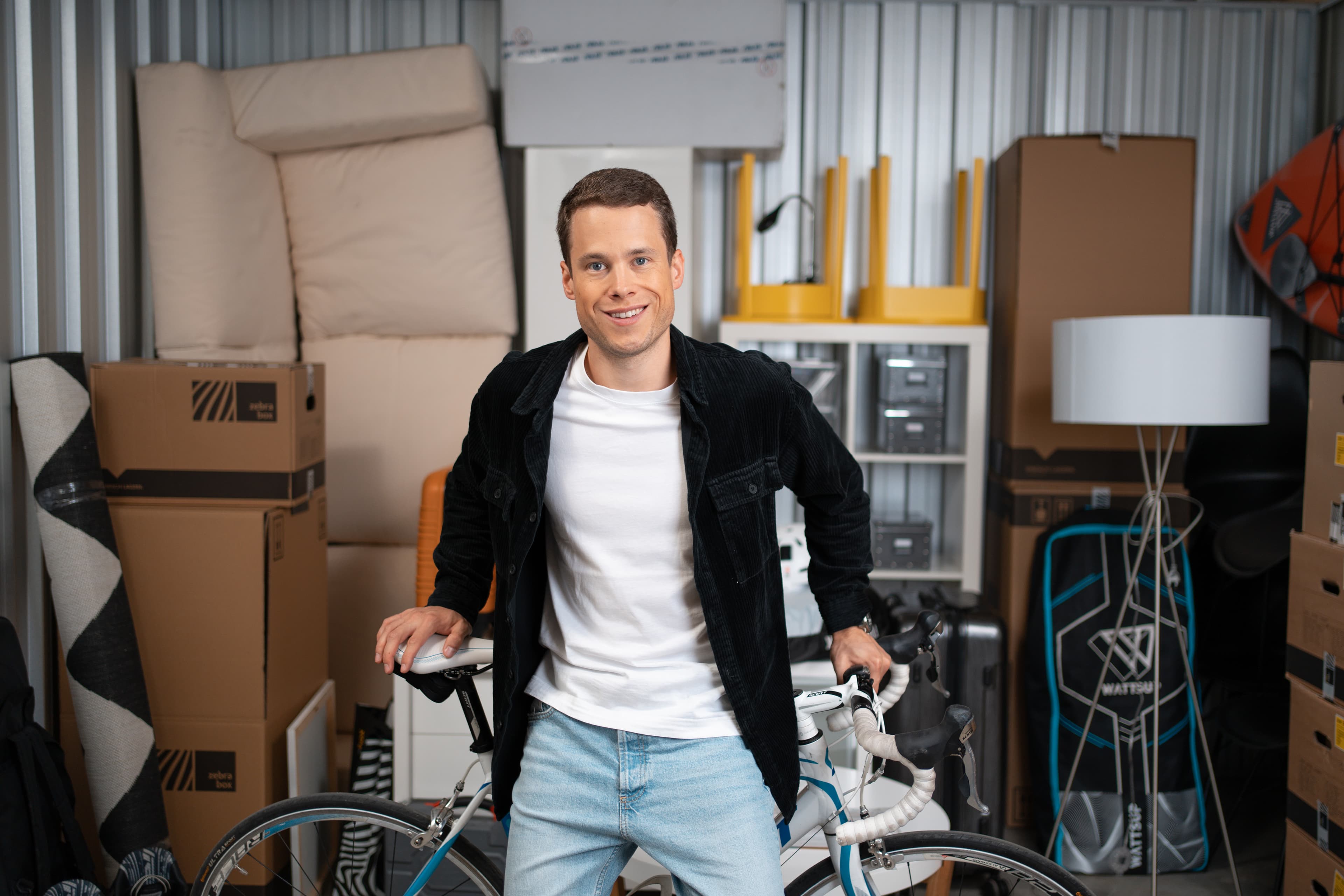 A young man sits on his bicycle, which is in his Zebrabox storage unit.