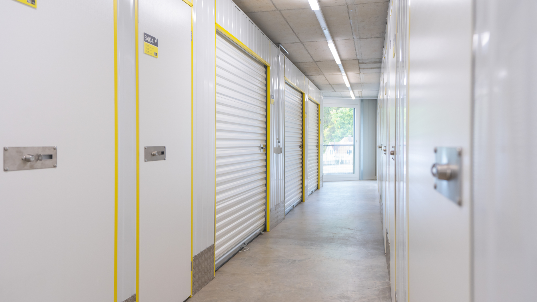 Interior view of the Zebrabox warehouse with individual storage units. The walls are made of sturdy white steel with yellow-edged doors.